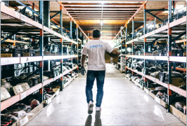 man walking down aisle of warehouse