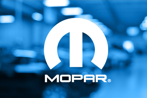 White Mopar Logo over a blurred image of a repair bay
